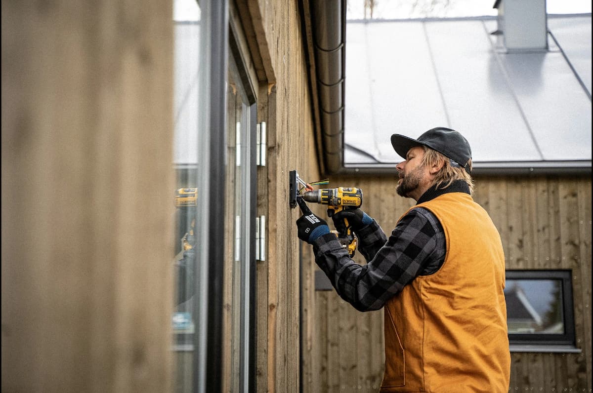 A man drilling on a wall